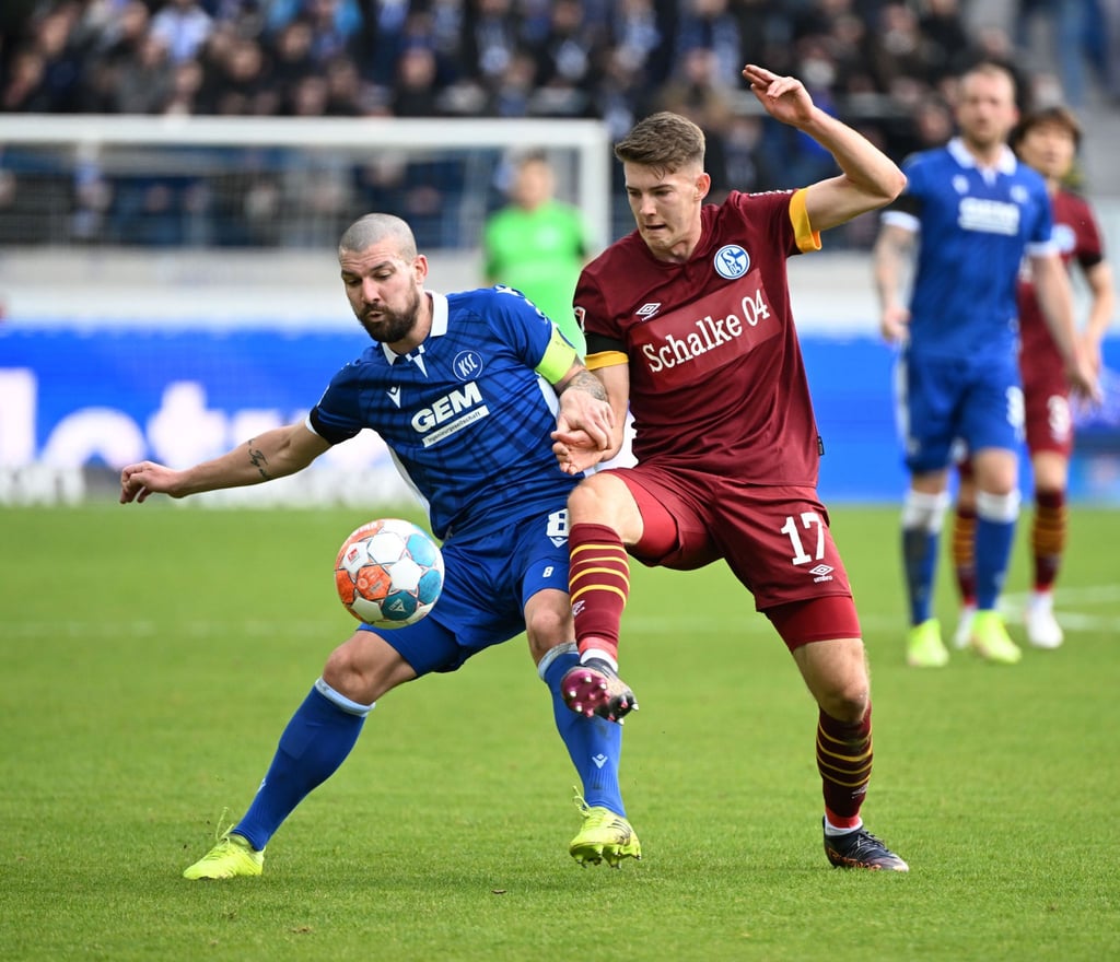 Der Karlsruher Jerome Gondorf (l) stellt seinen Körper zwischen den Ball und Gegenspieler Florian Flick.