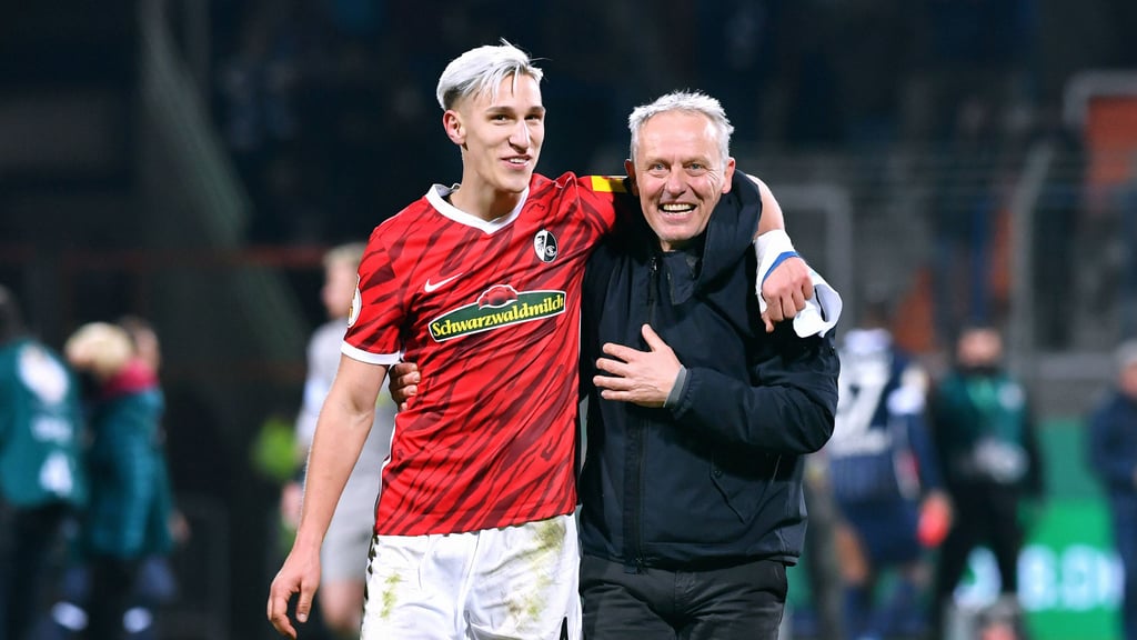 Nico Schlotterbeck (l.) und Cheftrainer Christian Streich freuen sich über den Pokalsieg gegen Bochum.