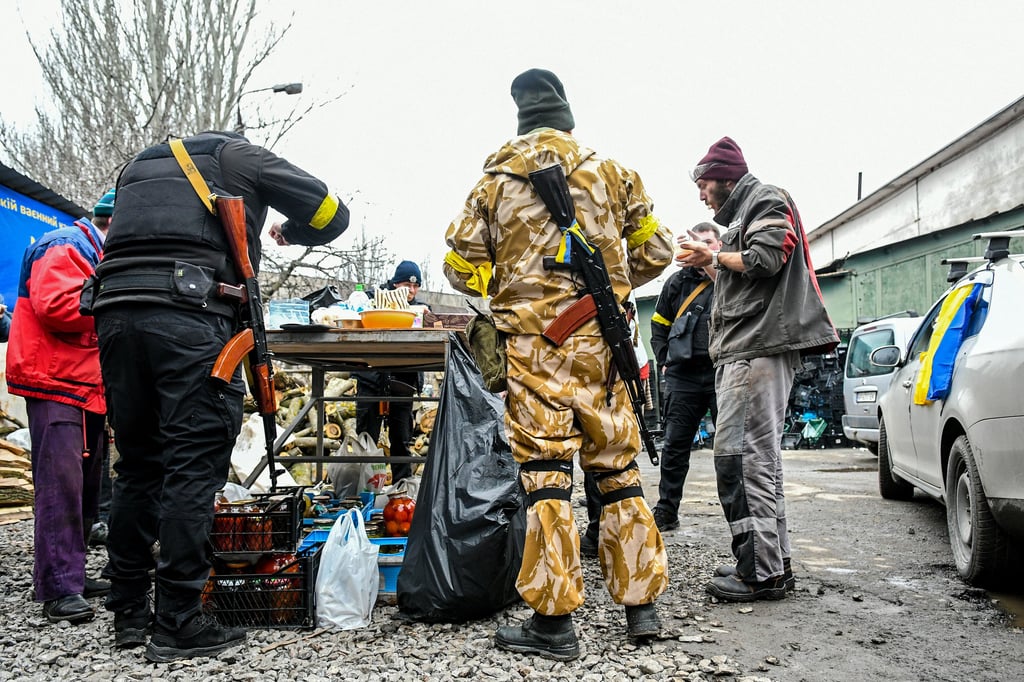 Ein Bild vom Donnerstag, 3. März 2022, in Saporischschja: Menschen essen auf dem Gelände des Verteidigungszentrums, das von einem lokalen Schausteller organisiert wurde.