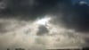 Die Sonne kommt nur kurzzeitig hinter einer dunklen Wolkendecke hervor.