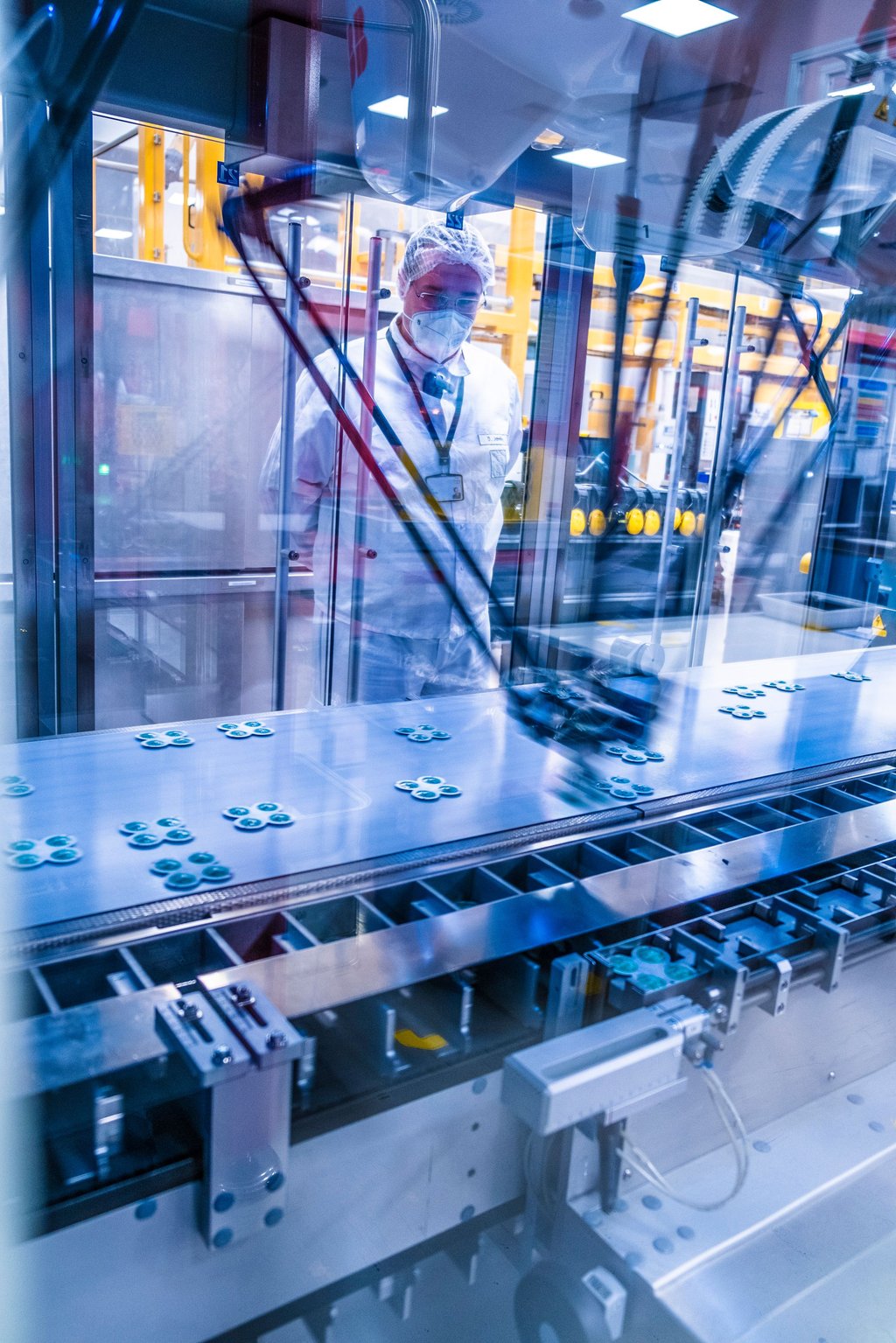 In der Verpackungsstraße greifen Roboterarme blitzschnell die Tabletten und stecken sie in Schachteln.