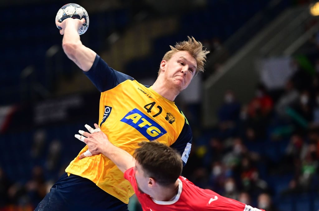 Schwedens Eric Johansson (l) kommt gegen Polens Piotr Chrapkowski zum Wurf.