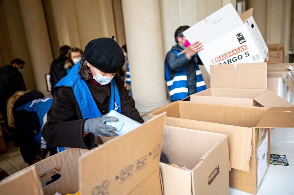 Freiwilige Helfer packen am Berliner Humboldt Forum Hilfsgüter in Kisten.