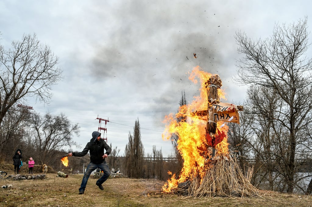 Auch das gehört zum Alltag im Ukraine-Krieg: Ein Mann macht sich seiner Wut Luft und wirft in Saporischja einen Molotowcocktail auf ein Bildnis von Wladimir Putin.