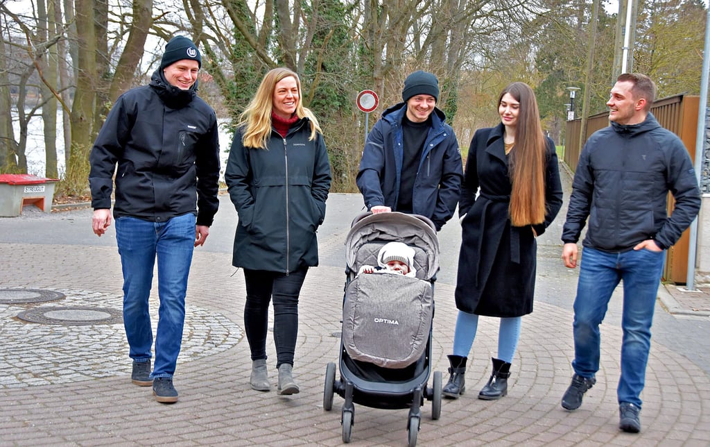 Abwechselnd schieben Miroslava (2.v.r.) und Dimitriy Drahushchak aus der Ukraine den Kinderwagen, in dem ihr Sohn Dominik sitzt. An der Seite des Paares spazieren Käthe Beilecke und Sohn Tom sowie Max Rosnerski. Alle sind erleichtert, dass die spektakuläre Rettungsaktion glücklich endete. Am Flechtinger Schloss-See kommen alle zur Ruhe und reden noch einmal über das Erlebte.