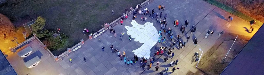 Das Bild einer Drohne zeigt die Demonstranten an der Friedenstaube auf dem Schulhof in Radegast.