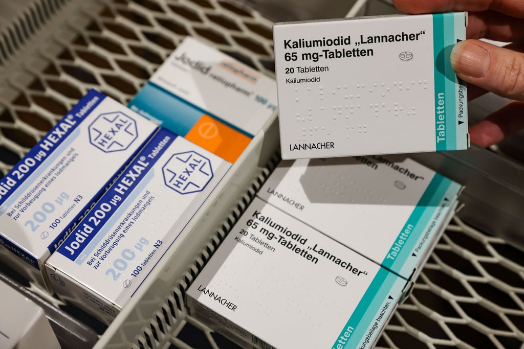 Eine Apothekerin nimmt eine Packung hochdosierte Jodtabletten aus einem Vorratsschrank, daneben liegen schwächer dosierte für Schilddrüsenerkrankungen.