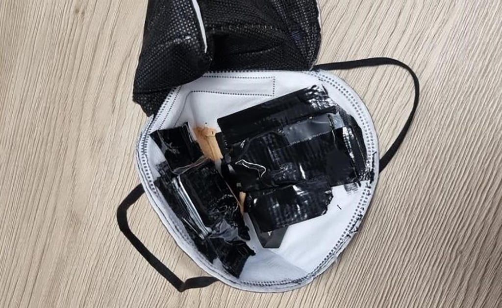 Eine eingenähte Kamera in einer FFP2-Maske liegt auf einem Tisch des TÜV Süd (undatierte Aufnahme). Sie war bei einer theoretischen Führerscheinprüfung entdeckt worden.
