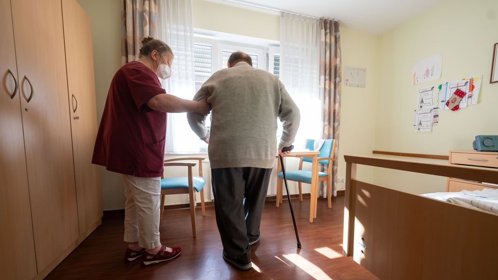 Eine Mitarbeiterin begleitet einen Bewohner in einem Seniorenheim. Allein 2019 registrierte die Heimaufsicht Hunderte Mängel in Heimen in Sachsen-Anhalt. Anspruch auf Einblick haben Pflegebedürtige und Angehörige trotzdem oft nicht.