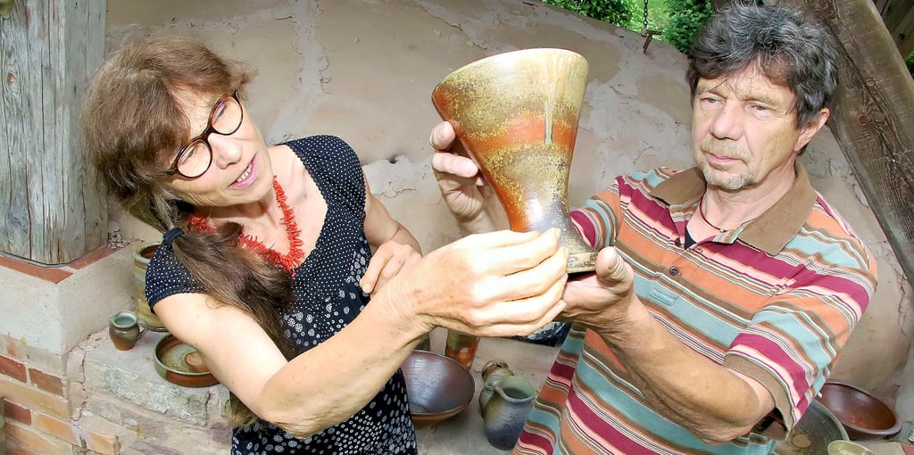 Carola und Reimar Krüger betrachten eine Vase, die sechs Tage und Nächte im großen Anagama gebrannt wurde.