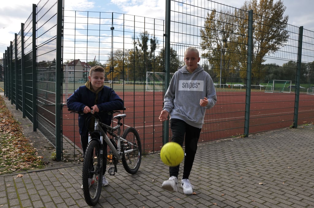 Amon (rechts) und sein Freund Oskar vorm umzäumten Sportplatz in ihrer Nachbarschaft - er ist zur öffentlichen Nutzung gesperrt.