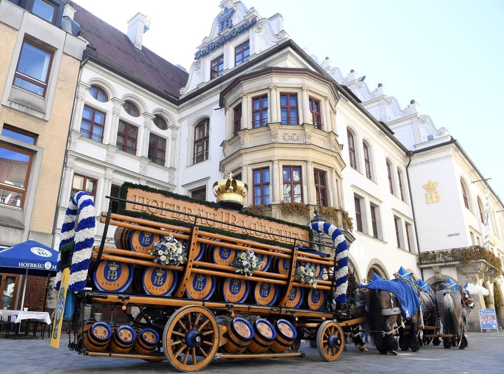 Eine Brauereikutsche steht vor dem Hofbräuhaus in München.