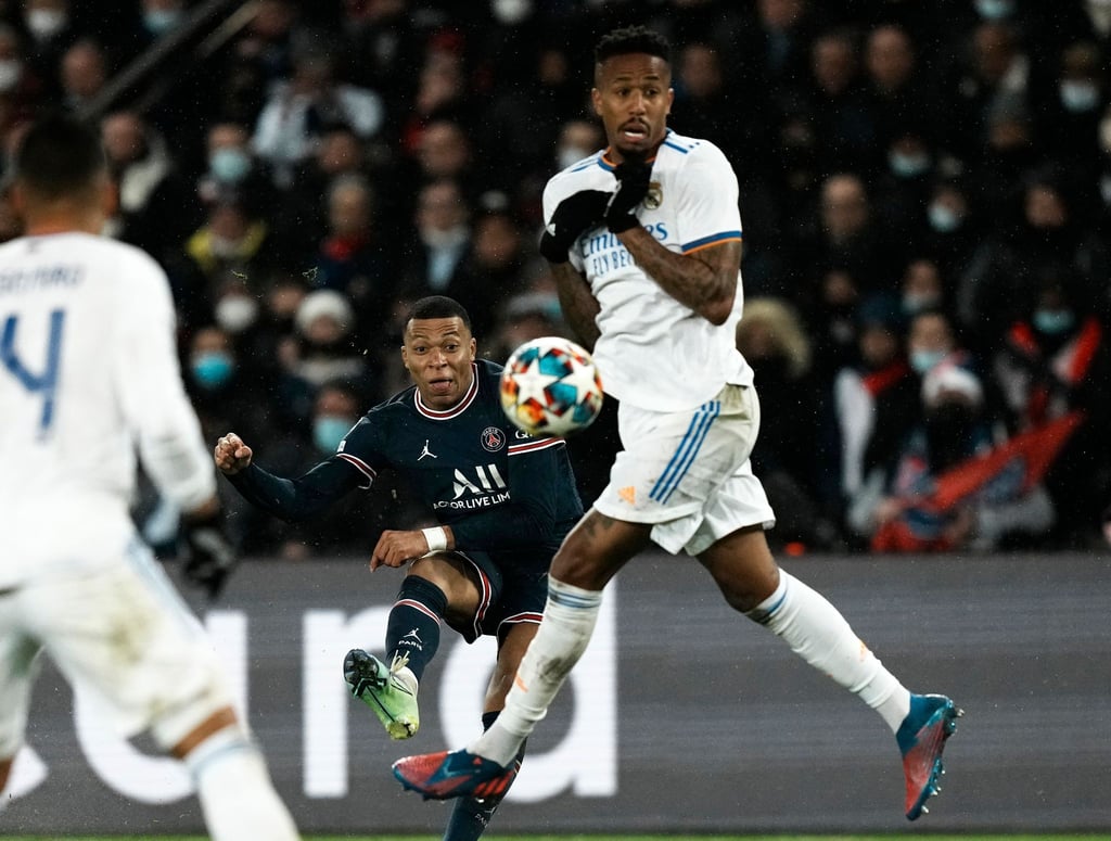 Kylian Mbappe (M) von Paris Saint-Germain (M) kommt gegen einen Abwehrversuch von Reals Eder Militao zum Schuss.