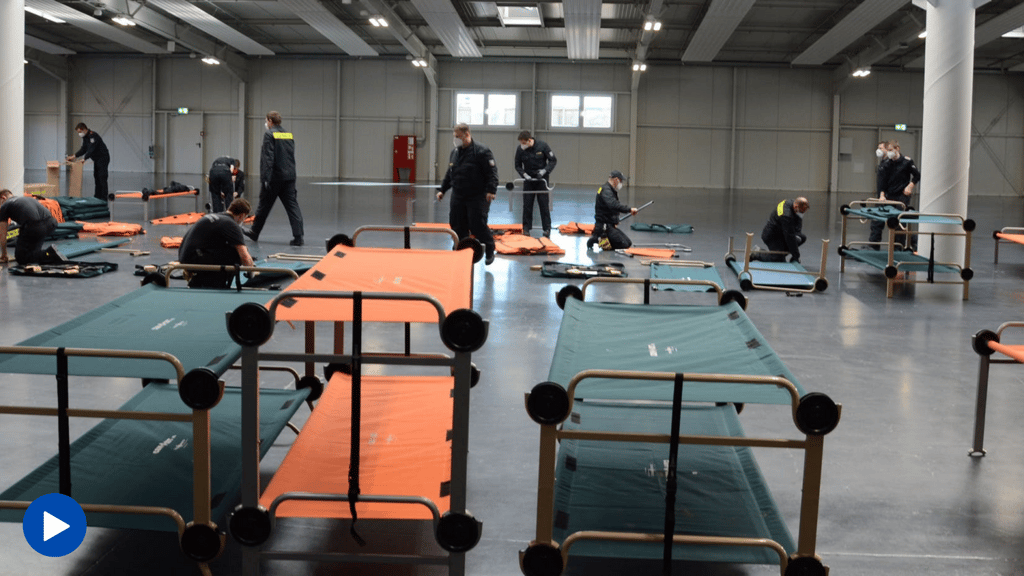 Kameraden von freiwilligen Feuerwehren der Stadt Magdeburg bauen in einer Halle Feldbetten auf. Hier werden Übernachtungsmöglichkeiten für Menschen aus der Ukraine geschaffen.