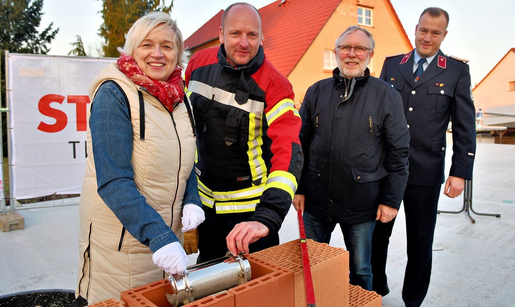 Bürgermeisterin Marlies Cassuhn und Ortswehrleiter Matthias Fischer haben am Donnerstagabend die sogenannte Zeitkapsel im Mauerwerk des neuen Feuerwehrgerätehauses in Farsleben einbetoniert.