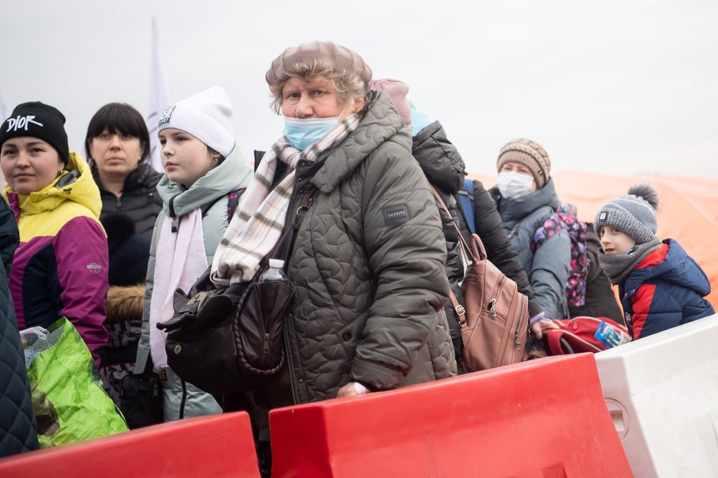 Geflüchtete aus der Ukraine stehen kurz hinter dem Grenzübergang Medyka für einen Bus an.
