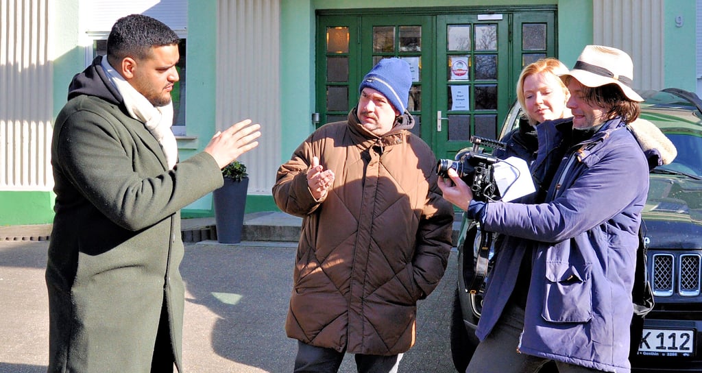 Schauspieler und Sänger Yasin el Harrouk alias Yonii (li.) mit Regisseur Teymour Tehrani, Assistentin Sophie Meyer und dem Genthiner Filmemacher Andy Kaiser bei den Dreharbeiten vor dem Genthiner Kino.