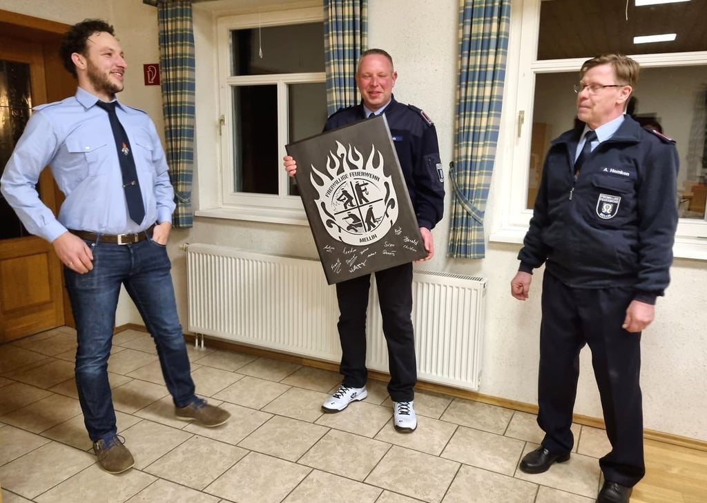 Nach sechs Jahren als Melliner Wehrleiter wurde Marko Schulz (Mitte) am Sonnabend feierlich verabschiedet. Sein Nachfolger Andreas Hemken (rechts) und Stellvertreter Knut Schwerin überreichten ihm ein Feuerwehrbild, auf dem sich die Kameraden mit ihrer Unterschrift verewigt haben.