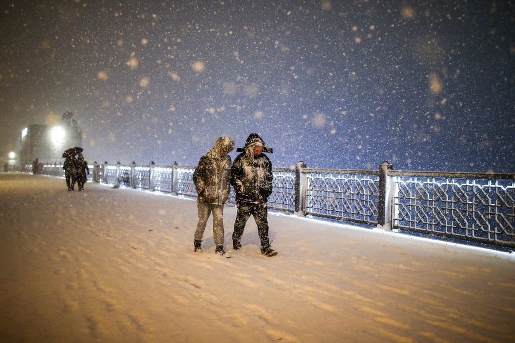 Fußgänger laufen bei Schneefall über die Galata-Brücke in Istanbul.