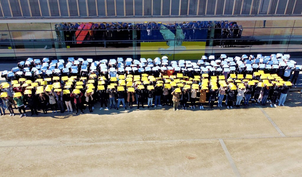 Die Schülerinnen und Schüler der BBS formen in Bitterfeld eine riesige Ukraine-Flagge.