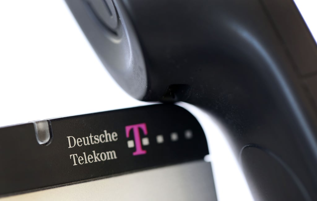 Illustration: Ein Telefonhörer auf einem beschrifteten Gerät der Deustchen Telekom.
