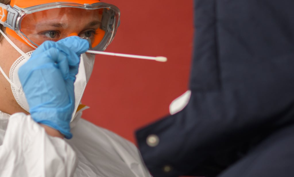Eine Mitarbeiterin nimmt einen Abstrich von einer Patientin für einen PCR-Test. Die bundesweite Sieben-Tage-Inzidenz erreichte am Montag nach Angaben des Robert Koch-Instituts (RKI) erneut einen Höchstwert.