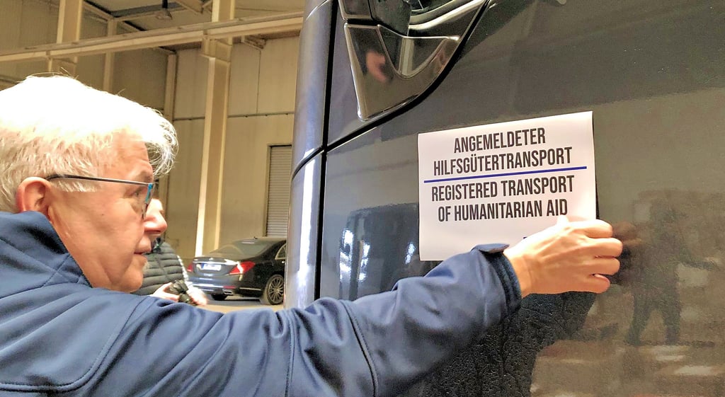Ralf Poschmann bringt den Hinweis auf den Hilfsgütertransport am Lkw an. Mittwochabend soll er sein Ziel erreicht haben.