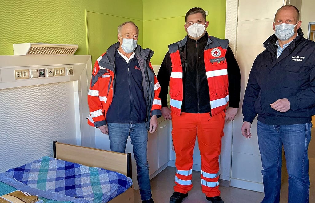 Zeigen eines der Zimmer in der Notunterkunft für ukrainische Kriegsflüchtlinge (von links): Bernd Birkholz von der Johanniter-Unfall-Hilfe, Christian Michael vom DRK und Sebastian Stoll, Erster Beigeordneter des Stendaler Landrates.