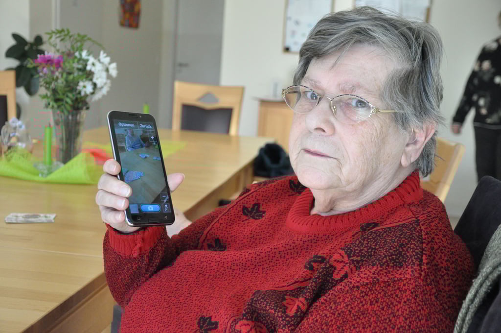Helga Uhlmann mit ihrem Smartphone. Fotografieren, Nachrichten schicken und Spielen sind kein Problem für die Seniorin.
