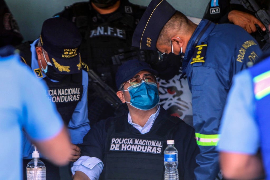 Juan Orlando Hernandez (M), Ex-Präsident von Honduras, spricht mit Polizeibeamten nach seiner Festnahme in seinem Haus.