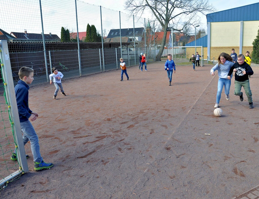 Kinder kicken auf dem Bolzplatz der Grundschule in Osterburg. Das Fußballfeld soll durch einen neuen Platz ersetzt werden.