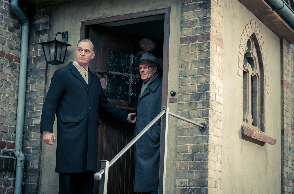 Pastor Holmer (Hans-Uwe Bauer, l) und Honecker (Edgar Selge) verlassen das Haus für einen Spaziergang.