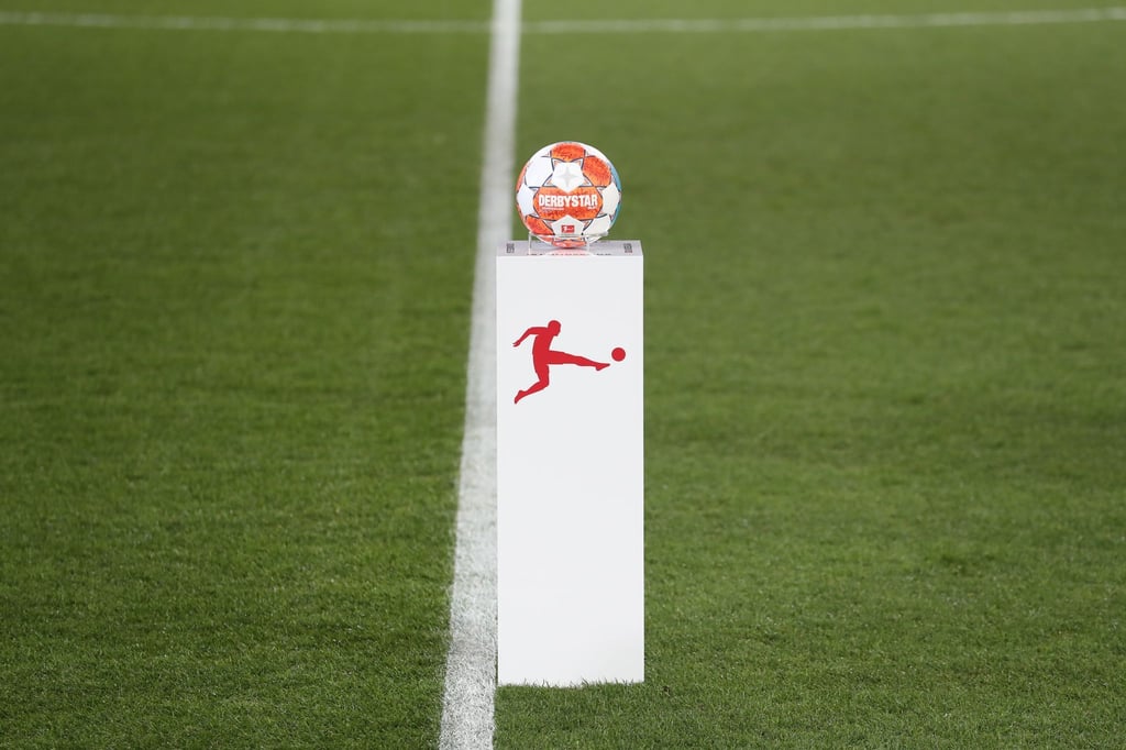 Das Logo der Deutschen Fußball Liga auf einem Sockel mit dem Spielball vor einem Bundesliga-Spiel.