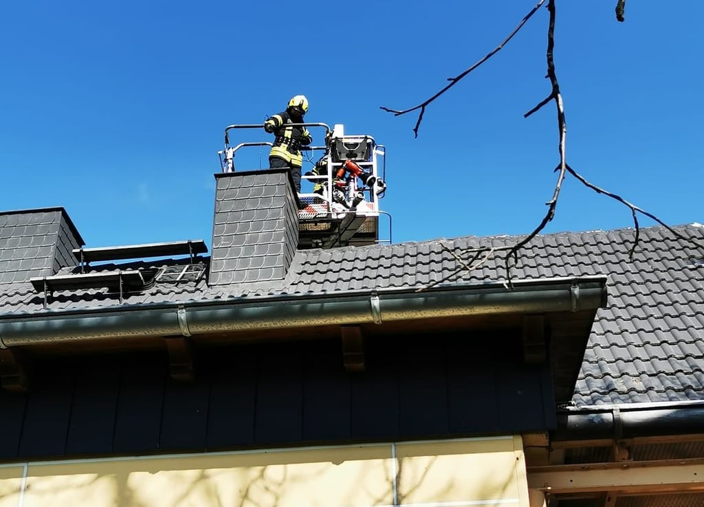 Vom Schornsteinkopf her bekämpfen die Jessener Kameraden den Brand