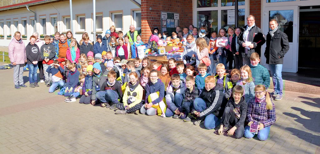 Schüler und ihre gespendeten Spielsachen. Mit dabei: Mitarbeiter der Grundschule, Schulleiter Frank Schiwek sowie Bürgermeister Bernd Nimmich.