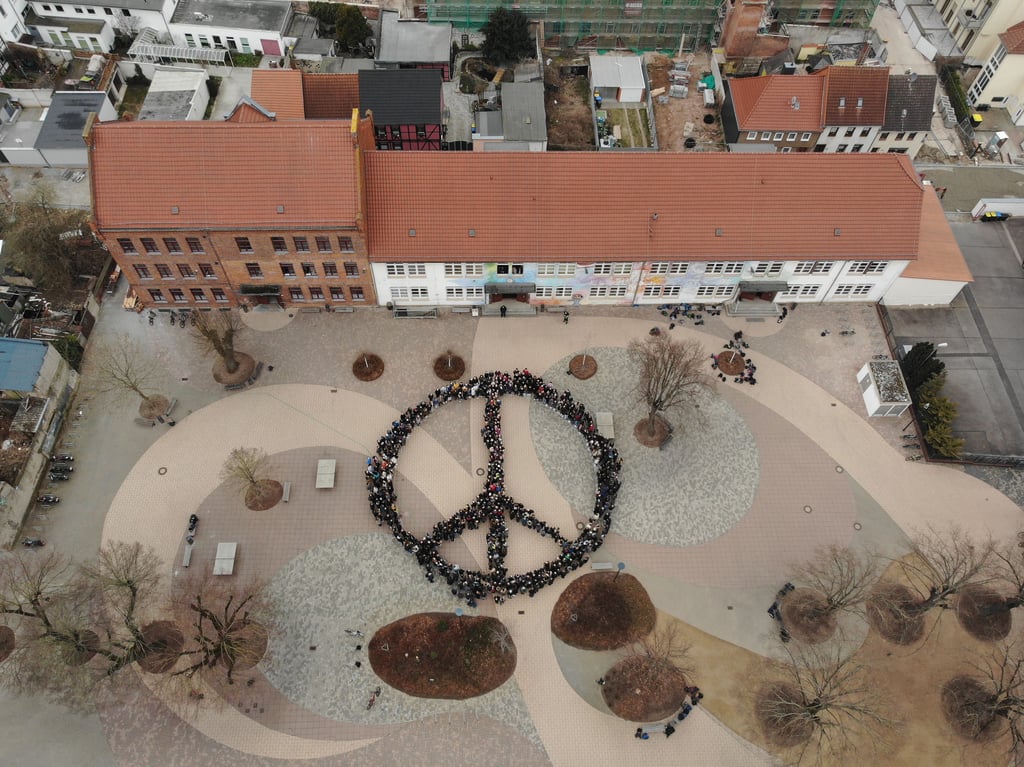 Bei einem Flashmob fanden sich die Schülerinnen und Schüler des Roland-Gymnasiums zusammen, um auf dem Schulhof das Friedenszeichen zu bilden.