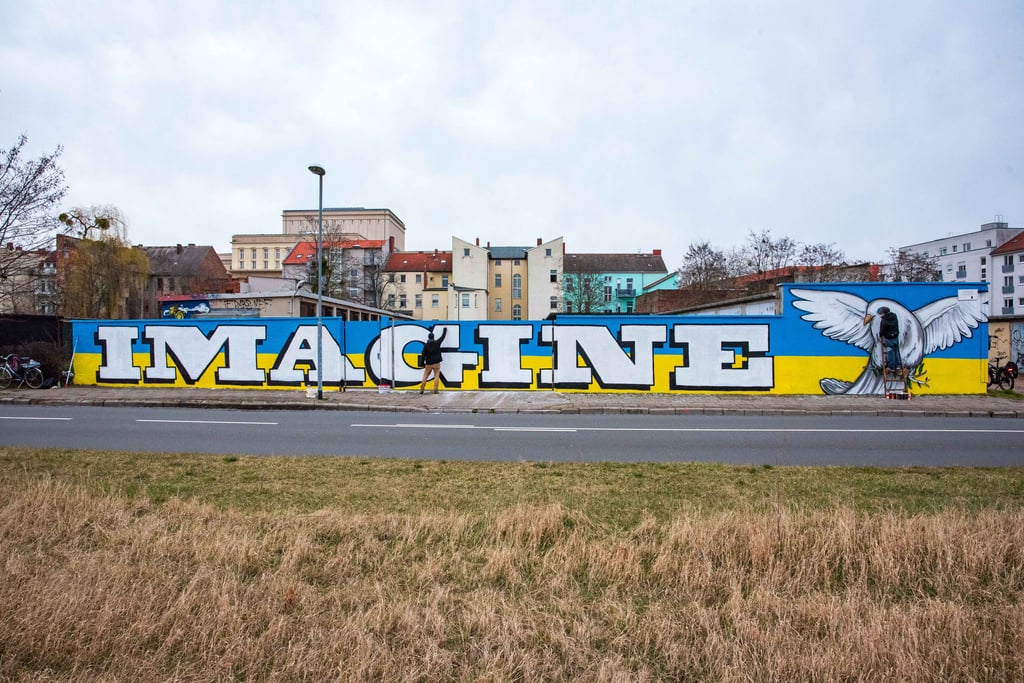 Ansage vor ukrainischen Nationalfarben: Das Graffiti (26 Meter lang, 2,50 Meter hoch) von Jakob Wolf (l.) und Till Neuenfels in der Bitterfeld Straße.