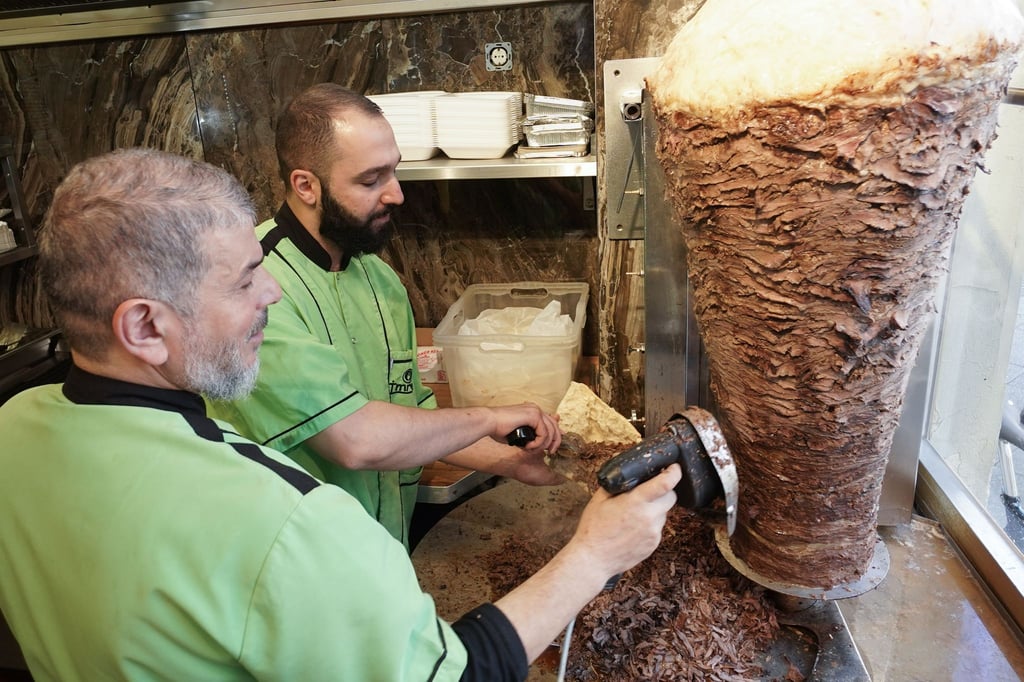 Halit (l) und Halip vom Imren Grill in Berlin bereiten einen Döner zu. Vor fünfzig Jahren soll er erfunden worden sein.