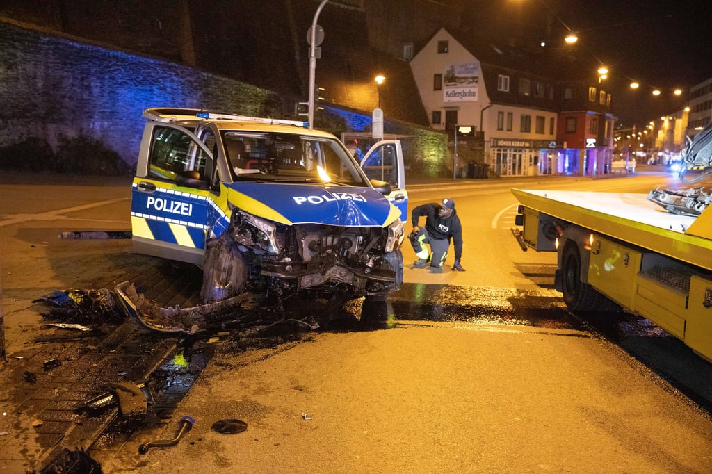 Ein demolierter Streifenwagen steht neben einem Abschleppwagen. Eine Polizistin war mit dem Wagen in Siegen von der Fahrbahn abgekommen und gegen einen Ampelmast geprallt.