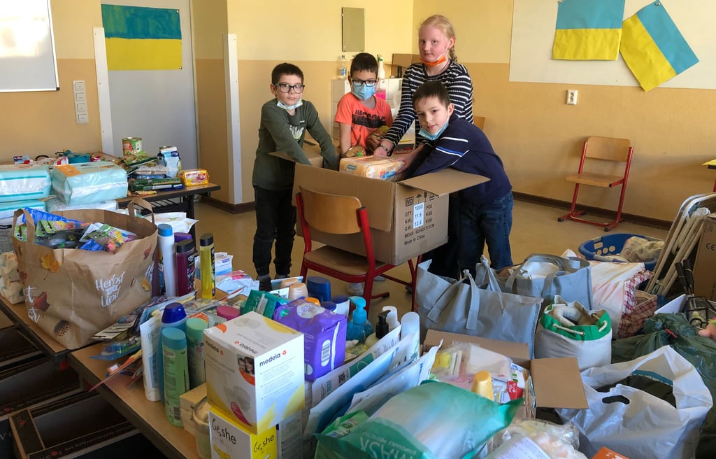 Domenik, Louis, Mia und Nicholas verstauen Spenden in einem Karton, die an der Grundschule Goethe in Sangerhausen gesammelt wurden.