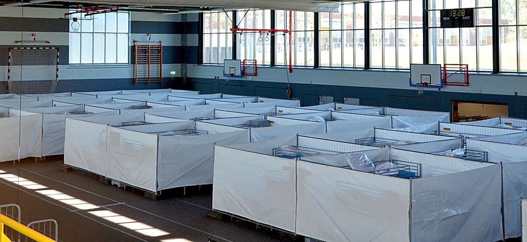 Schlafplatz statt Sporthalle: In diesen provisorisch errichteten Schlafkabinen aus Bauzäunen und Abdeckplanen können mehr als 100 Menschen vorübergehend unterkommen.