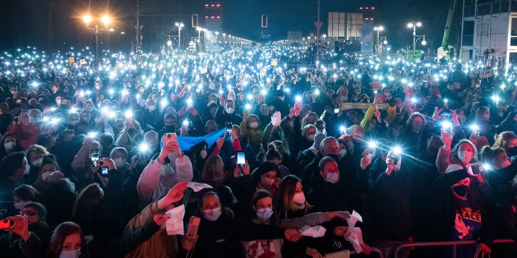 Zahlreiche Zuschauer leuchten mit ihren Handy-Taschenlampen bei „Sound of Peace“ am Brandenburger Tor.