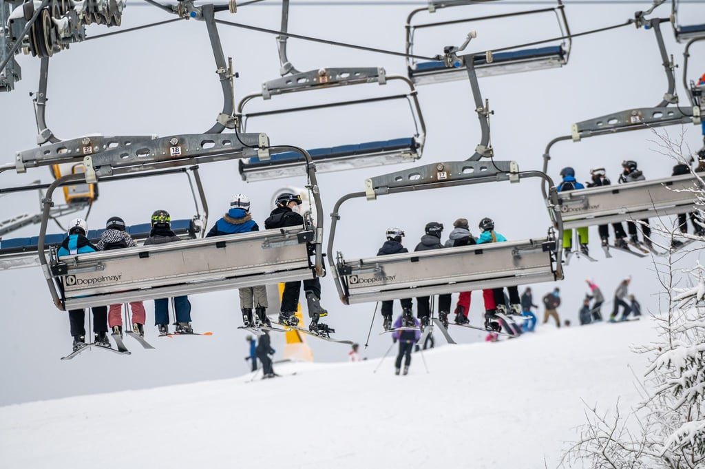Skifahrer sitzen im Sessellift. Auch in Corona-Zeiten sind Spaziergänge, Rodeln und Skifahren im Sauer- und Siegerland sehr beliebt und mit wenigen Einschränkungen sehr gut möglich.