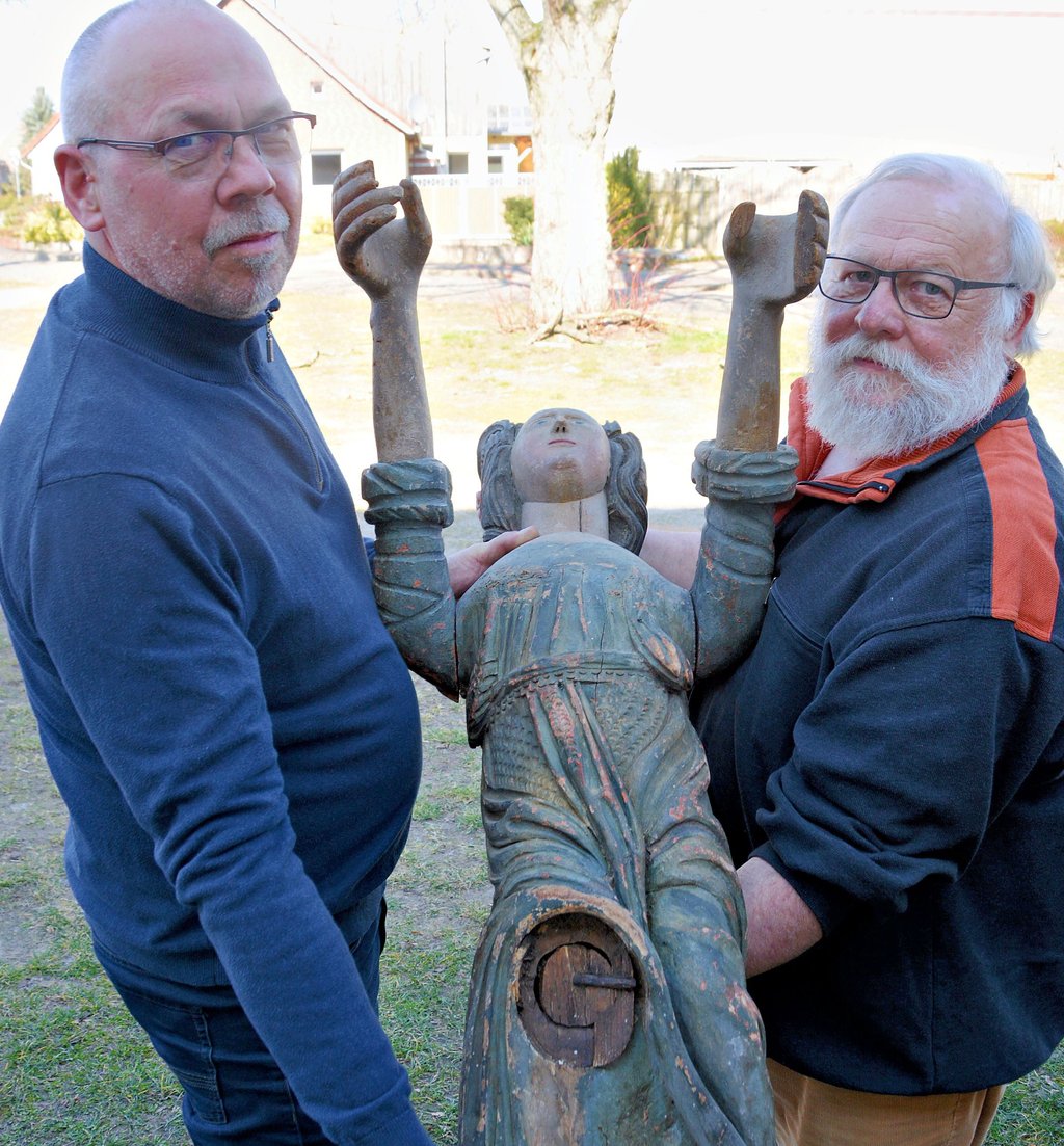 Andreas Gädecke (links) vom Gemeindekirchenrat Kusey und Restaurator Reinhold Gonschior mit dem Kuseyer Taufengel. Er ist etwa 270 Jahre alt und stammt aus der ehemaligen Kuseyer Kirche, die nicht mehr existiert.