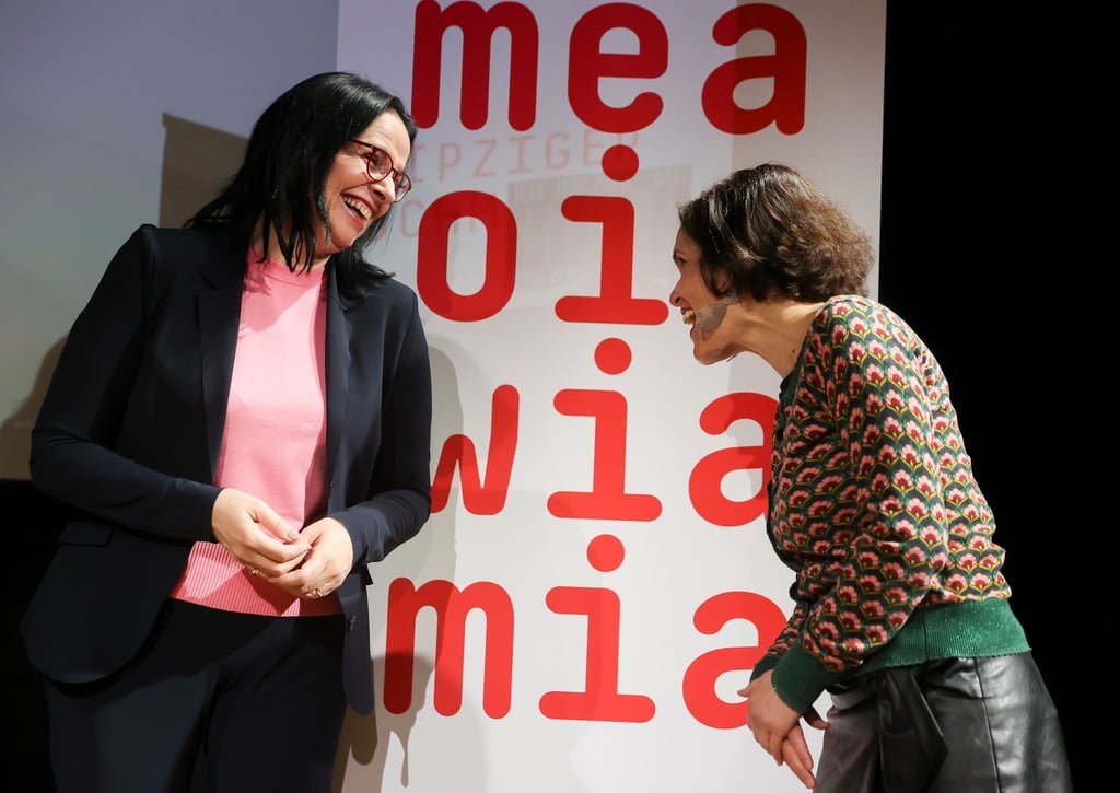 Andrea Mayer (l), Staatssekretärin im österreichischen Kulturministerium, und Katja Gasser, Künstlerische Leiterin des Gastland-Projekts, präsentieren während der Programmvorstellung Österreichs als Gastland der Leipziger Buchmesse 2023 den Slogan.