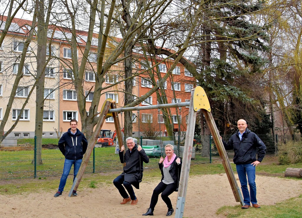 Mario Niese (von links), Abteilungsleiter Technik der Wobau Haldensleben, Detlef Koch, Geschäftsführer der Wobau sowie der Stadtwerke, Nicole Heinrichs, Abteilungsleiterin Wohnungswirtschaft der Wobau sowie Reiko Freier vom Netzbetrieb der Stadtwerke bei einem Vor-Ort-Termin an der Rottmeisterstraße. Im Hintergrund sind die Solarmodule auf dem Wohnblock zu sehen.