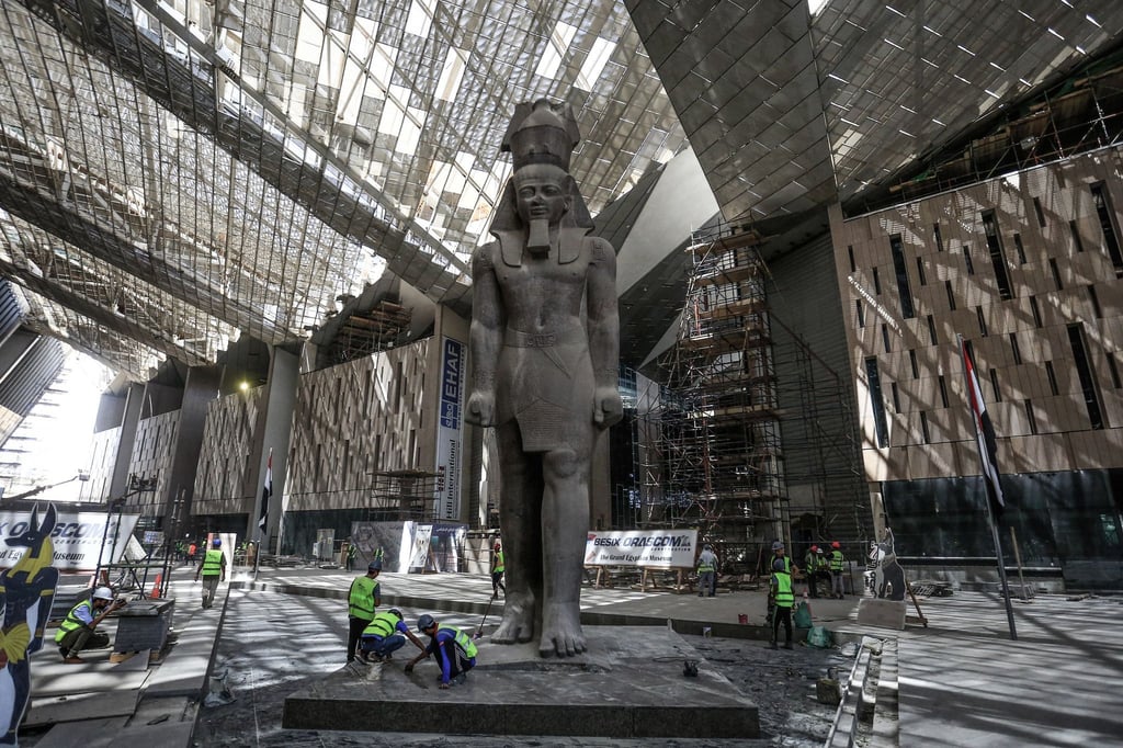 Arbeiter reinigen den Bereich neben der riesigen Statue des ägyptischen Pharaos Ramses II. in der Halle des Großen Ägyptischen Museums.