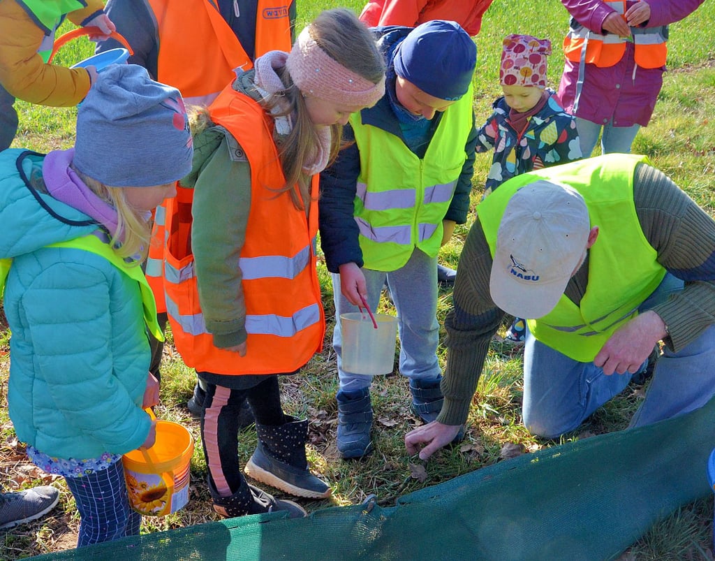Michael Wunschik vom Naturschutzbund erklärt den freiwilligen Helfern, worauf sie zu achten haben. Ziel ist es, Kröten sicher auf die andere Straßenseite zu bringen.