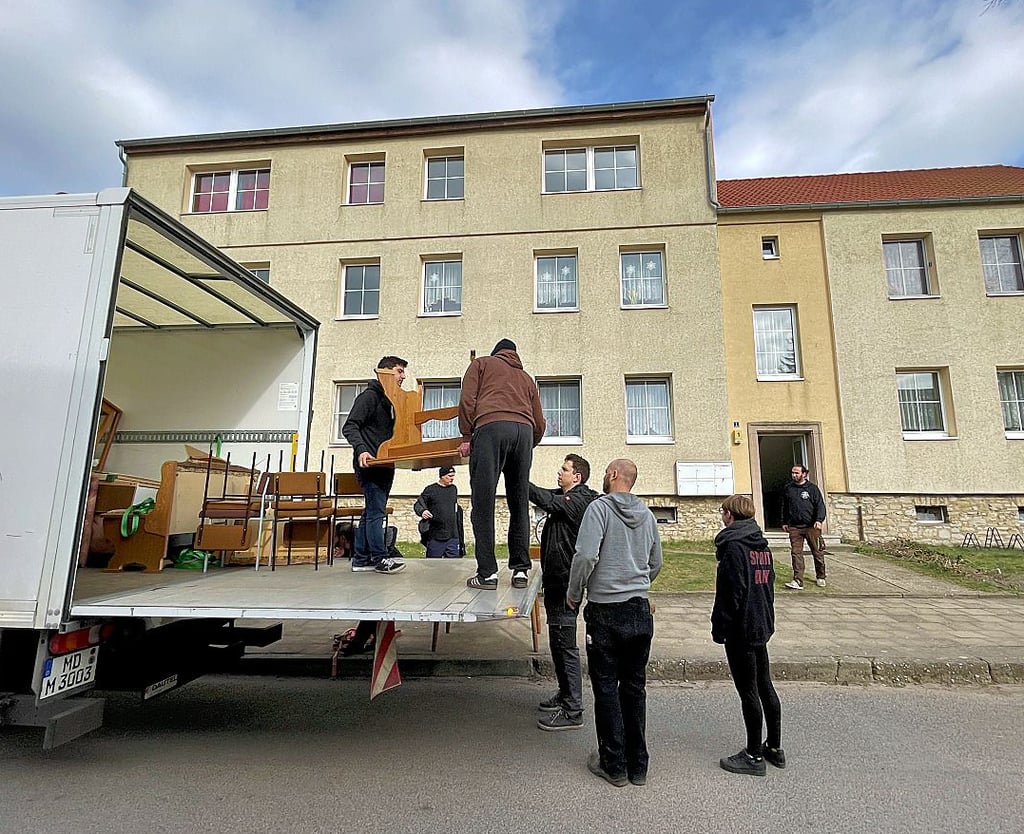 Ehrenamtliche Helfer bringen Möbel in eine leere Wobau-Wohnung im Triftweg.