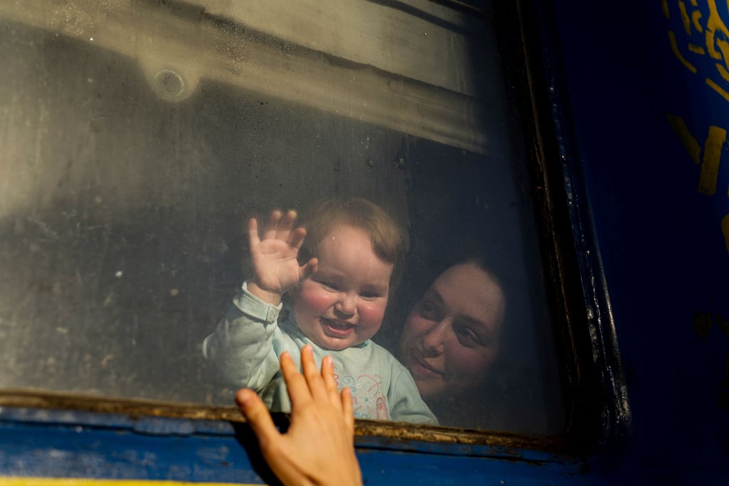 Eine Frau mit einem Kind aus Mariupol verabschiedet sich von ihrem Freund, bevor ihr Zug vom Bahnhof in Magdeburgs ukrainischer Partnerstadt Saporischja nach Lemberg abfährt.